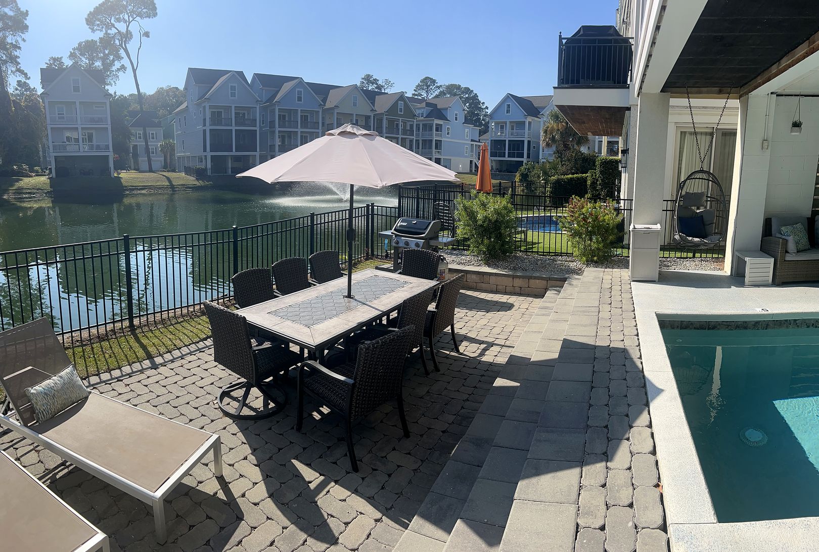 Pool, paver patio, dining table and the lagoon with its fountain at 122 Sandcastle Court